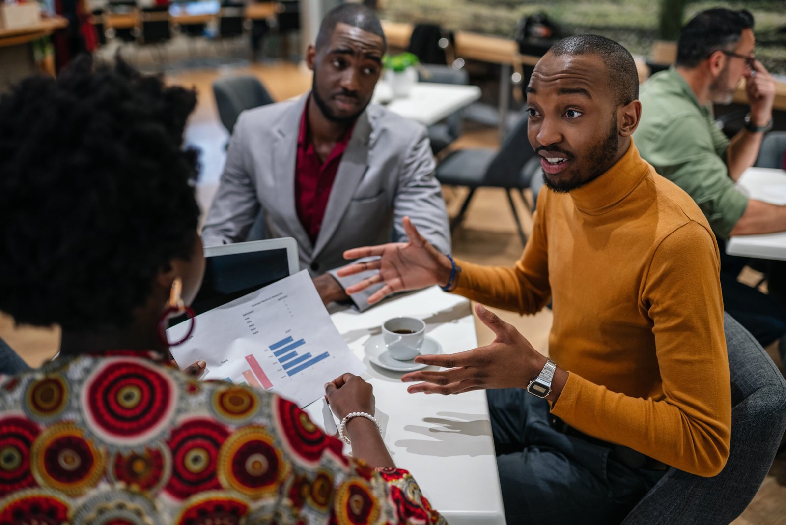 Black african business team meeting in discussion sitting in office canteen